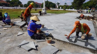 Sejumlah pekerja terlihat sedang menata batu andesit di area jogging track Alun-alun 1 Jepara, Selasa (10/9/2024).