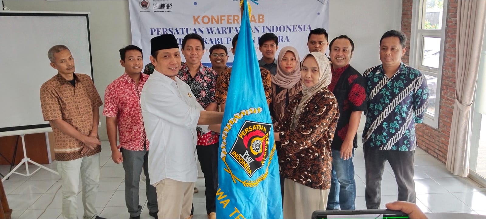 Sekretaris PWI Jateng Setiawan Hendra Kelana dan Ketua PWI Jepara periode 2025-2028 Septina Naviyanti memegang pataka PWI di sela-sela kegiatan Konfercab PWI Jepara yang digelar Jumat (31/1/2025).